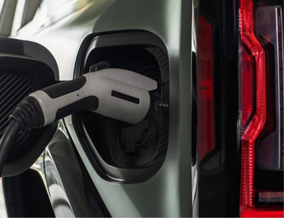 Close up of charging port with charger plugged in on a GMC Hummer EV SUV - Crenwelge GMC Kerrville in Kerrville TX